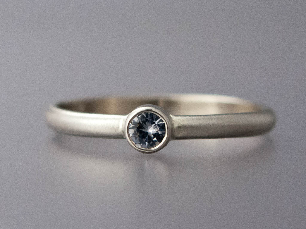 White Sapphire Solitaire Engagement Ring with a 3 mm - 5 mm Sapphire in a Straight Bezel and a Classic 2mm Low Domed Band in 14k Gold